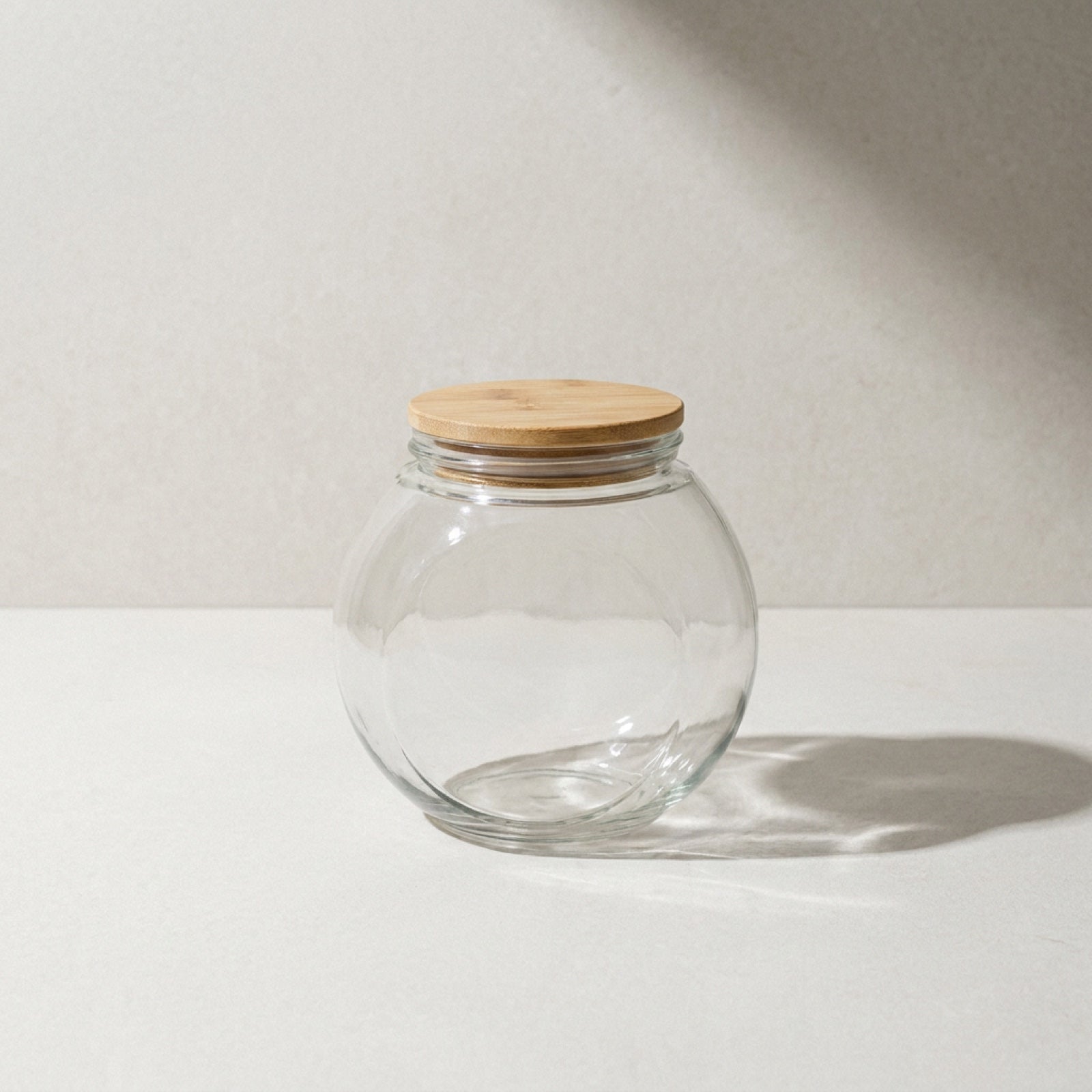 Kensington London glass storage jar with airtight bamboo lid on pale limestone