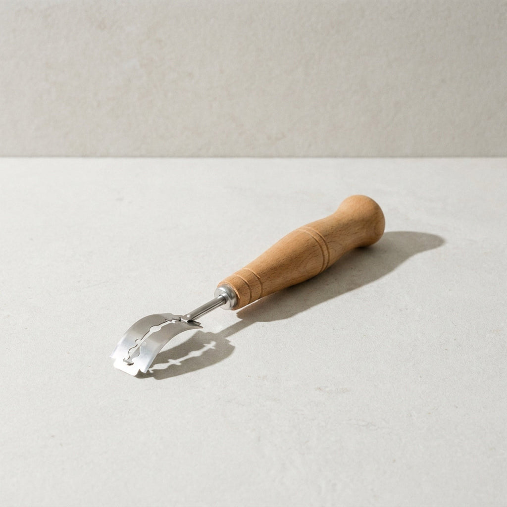 Kensington London bread lame with beech handle and stainless steel arm on pale limestone