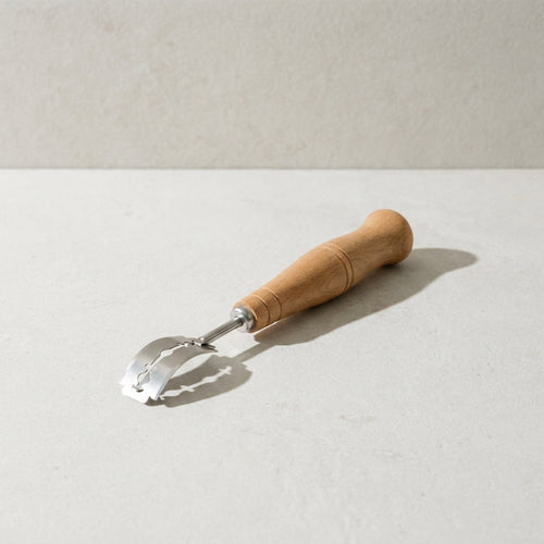Kensington London bread lame with beech handle and stainless steel arm on pale limestone