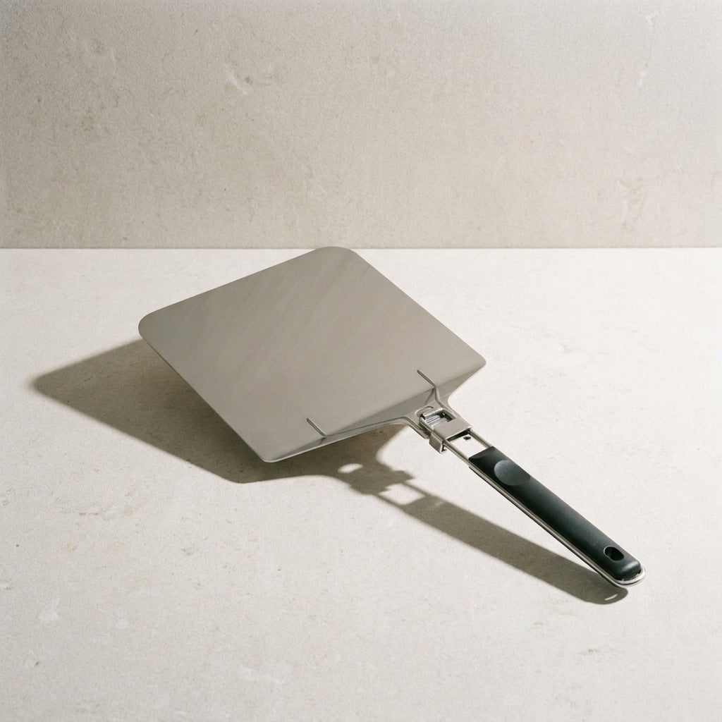 Kensington London folding stainless steel pizza peel on pale limestone