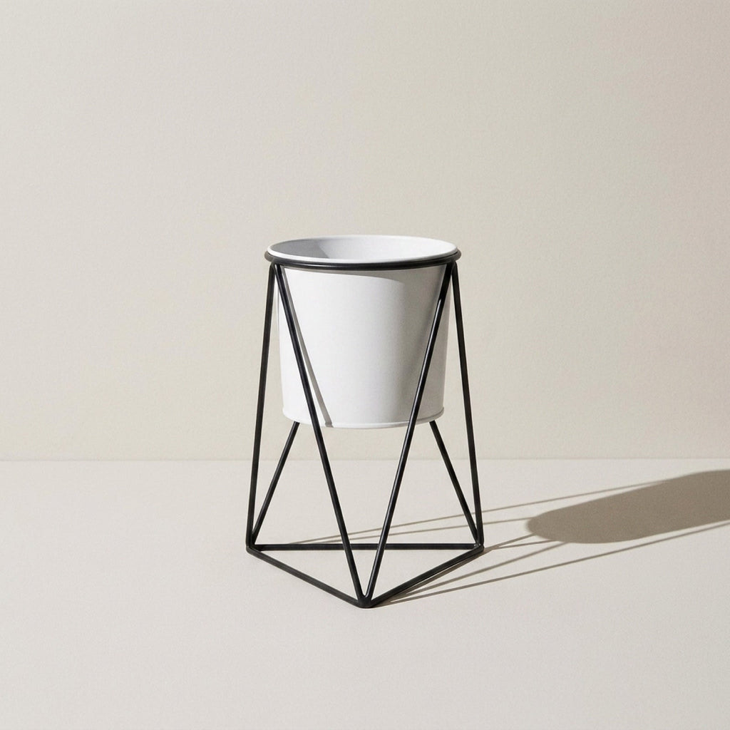 Kensington London black iron tripod plant stand with white pot on pale limestone