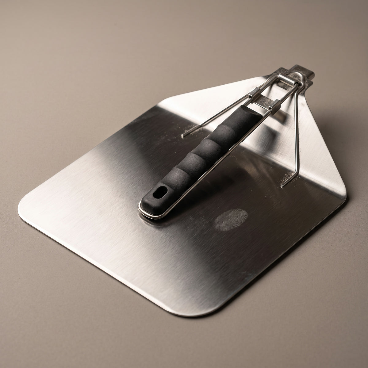 Folding pizza peel closed, showing the hinge